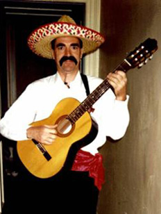 Andy with fake moustache, mexican hat, and guitar. At Edinburgh Festival.